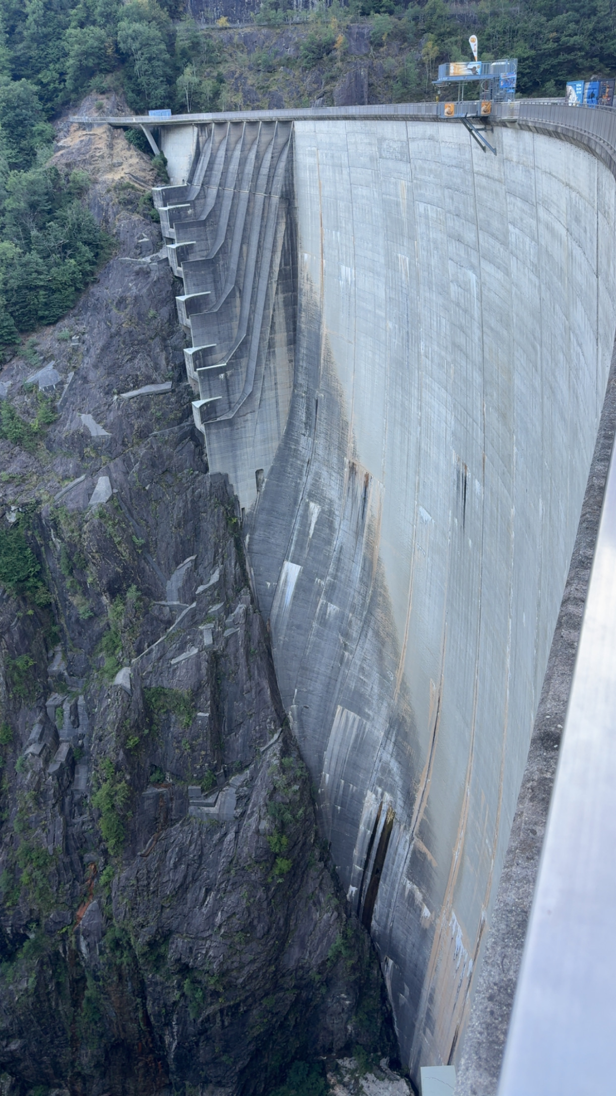 Blick der Verzasca-Staumauer entlang steil in die Tiefe.